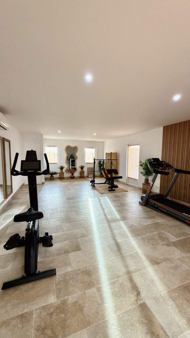 La salle de sport de la Maison Maën : vélo, tapis de course, banc de musculation